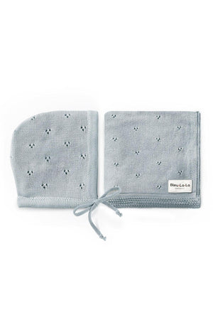 Light blue organic cotton pointelle swaddle blanket and hat set, featuring delicate patterns and a branded label.