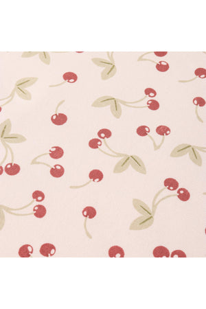 A light fabric featuring a playful cherry print, with red cherries and green leaves on a soft background. This design is perfect for a lightweight, organic cotton dress.