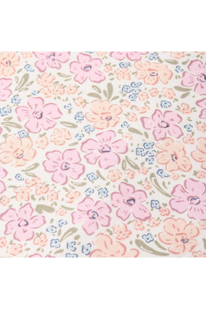 A close-up view of a floral fabric featuring pink and blue flowers on a cream background. This organic cotton material showcases a delicate design, perfect for childrens clothing.