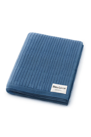 Blue ribbed knit cotton blanket with a label reading Bleu-La-La Organics, folded neatly on a white background.