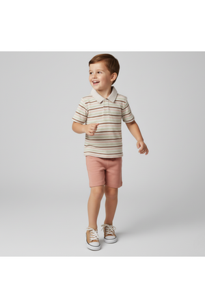 A young boy wears a striped collar tee in earthy tones and pink shorts, showcasing a playful style.