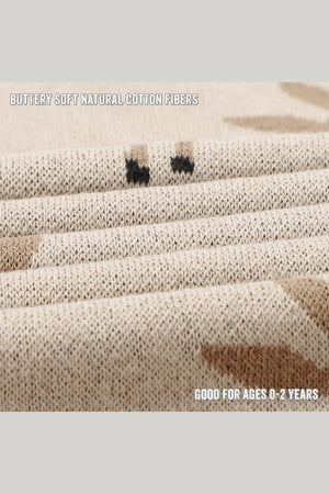 Close-up of a beige knit fabric with subtle deer patterns, made from soft natural cotton fibers.