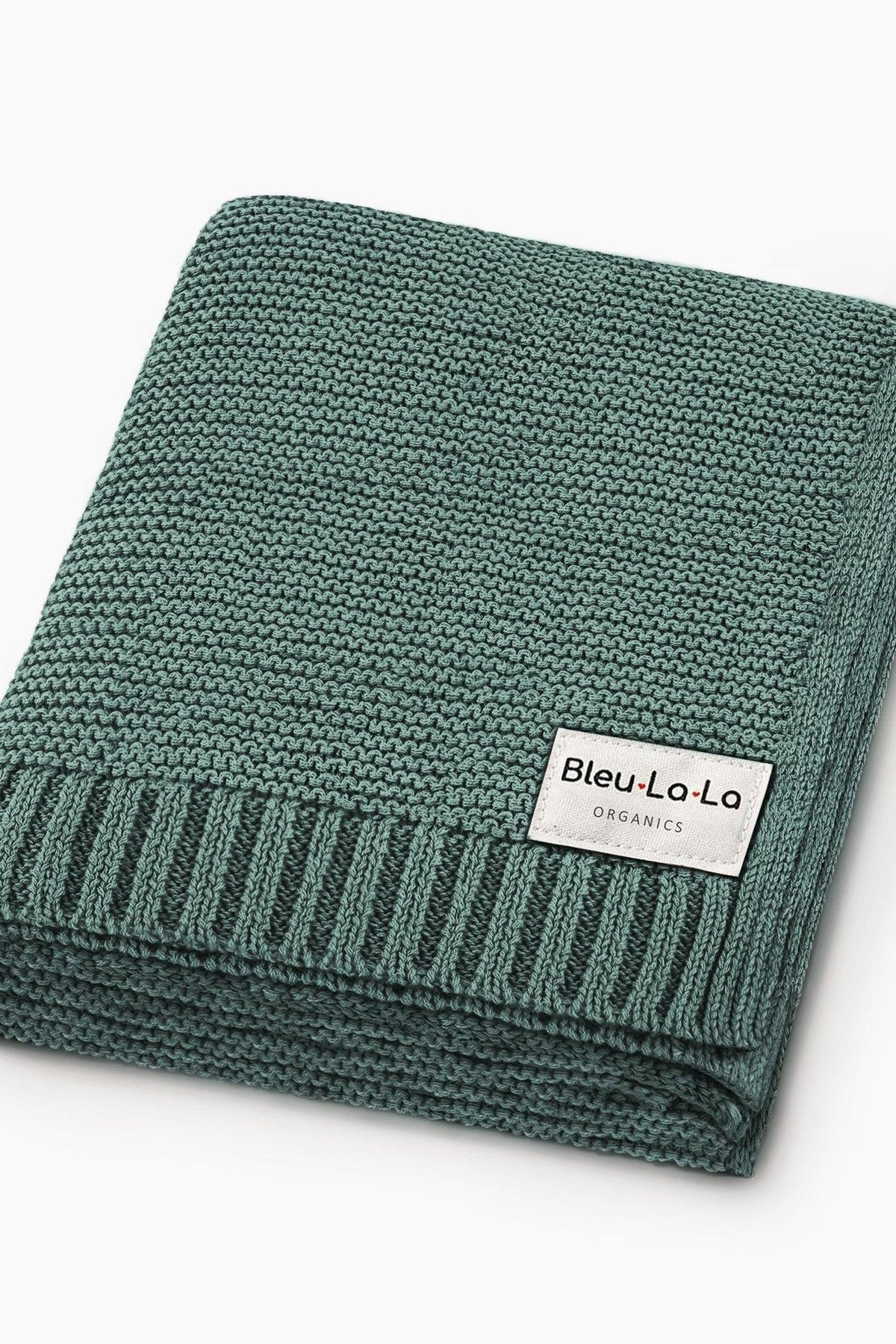 A folded green knit blanket with a Bleu La La Organics label, showcasing a textured, ribbed edge.