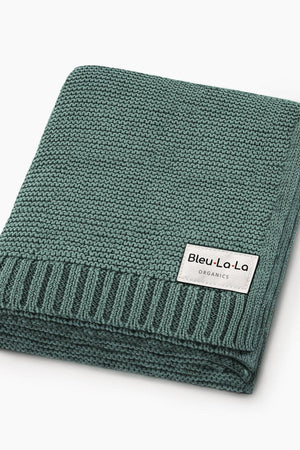 A folded green knit blanket with a Bleu La La Organics label, showcasing a textured, ribbed edge.