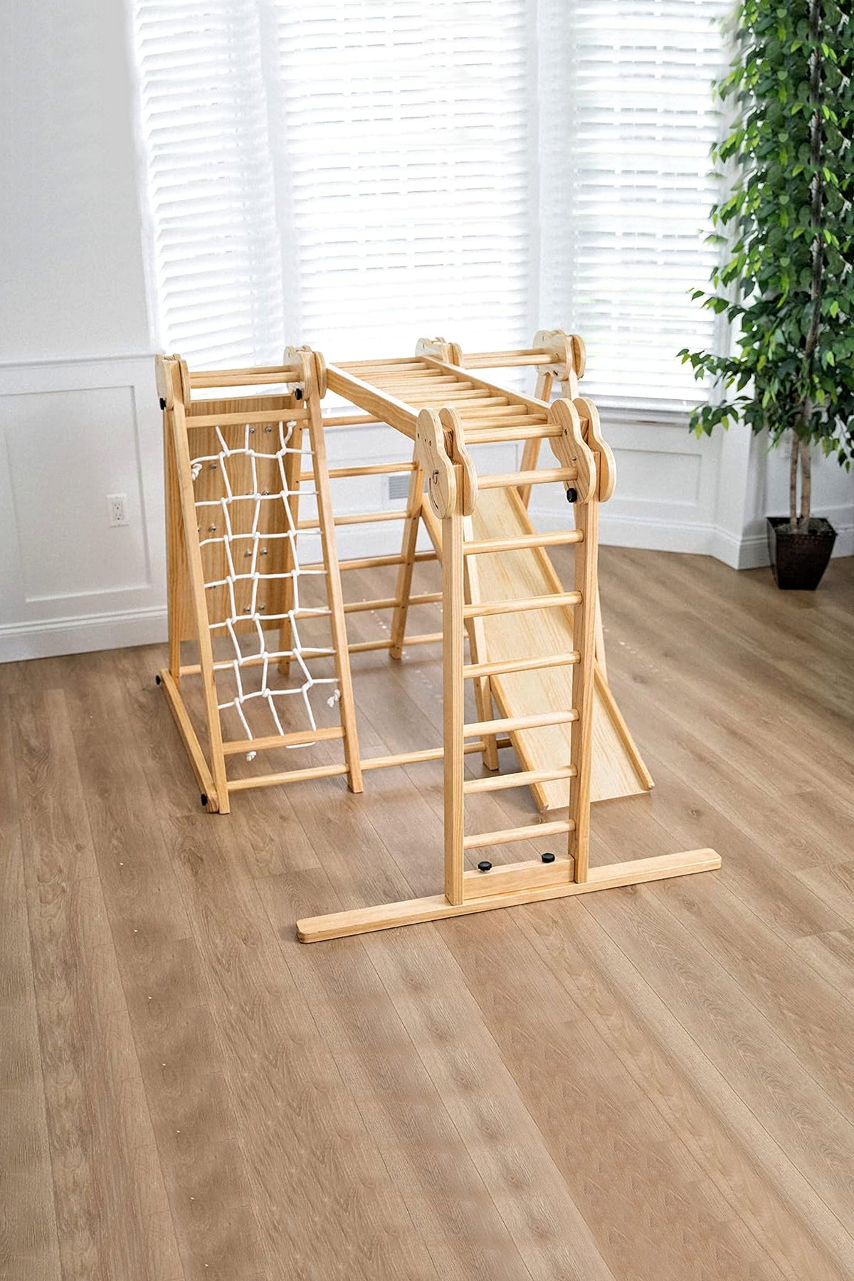 Wooden foldable jungle gym for toddlers with climbing and sliding features, set in a bright indoor room.