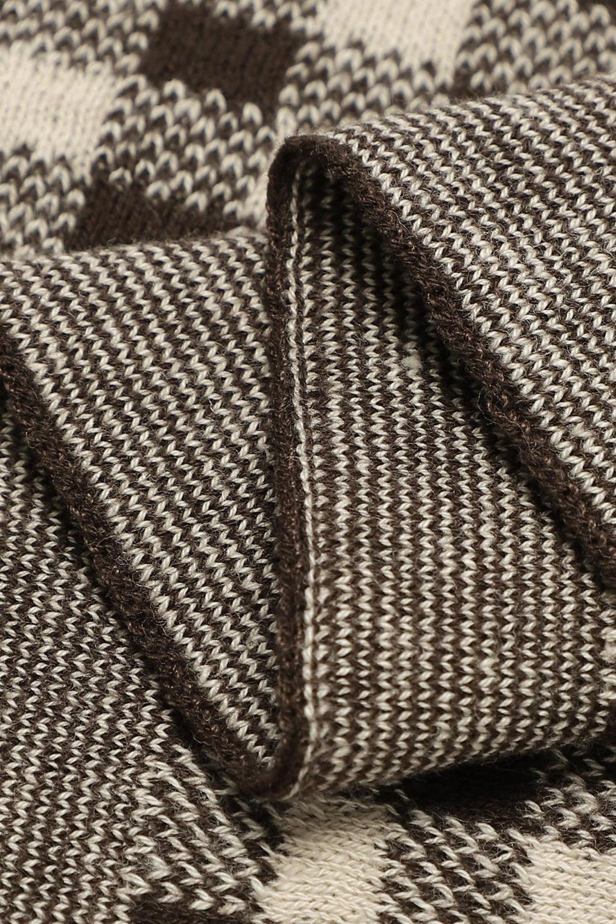 Close-up of a brown and cream checkered knit fabric, showcasing the detailed texture and pattern.