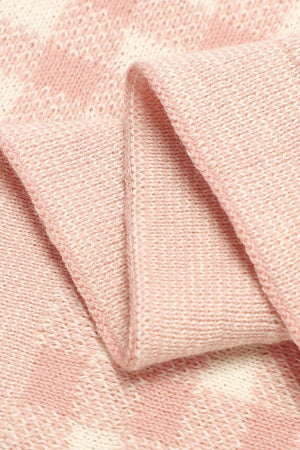 Close-up of a pink and white checkered knit blanket, showcasing its soft texture and intricate pattern.