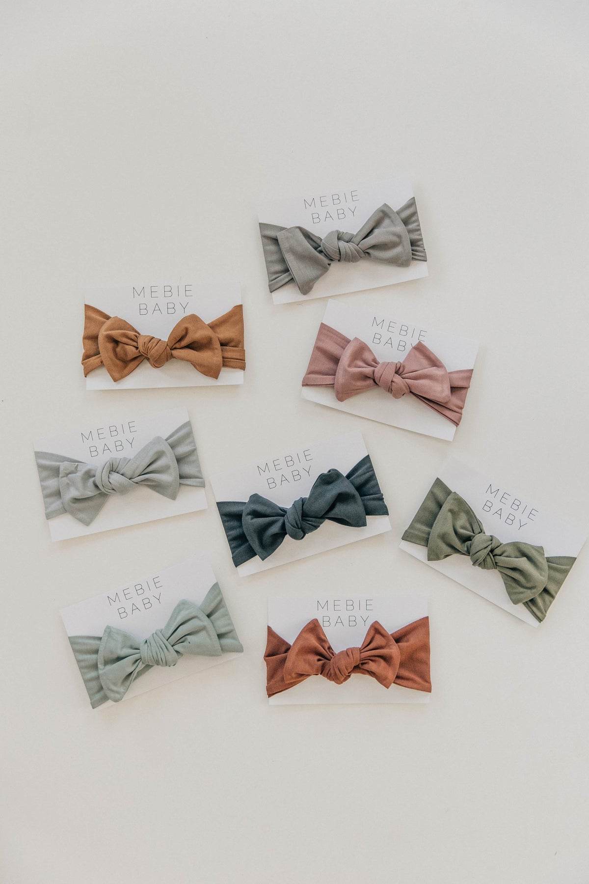 Assorted Mebie Baby head wraps in various earthy tones displayed on cards, made from soft bamboo fabric.