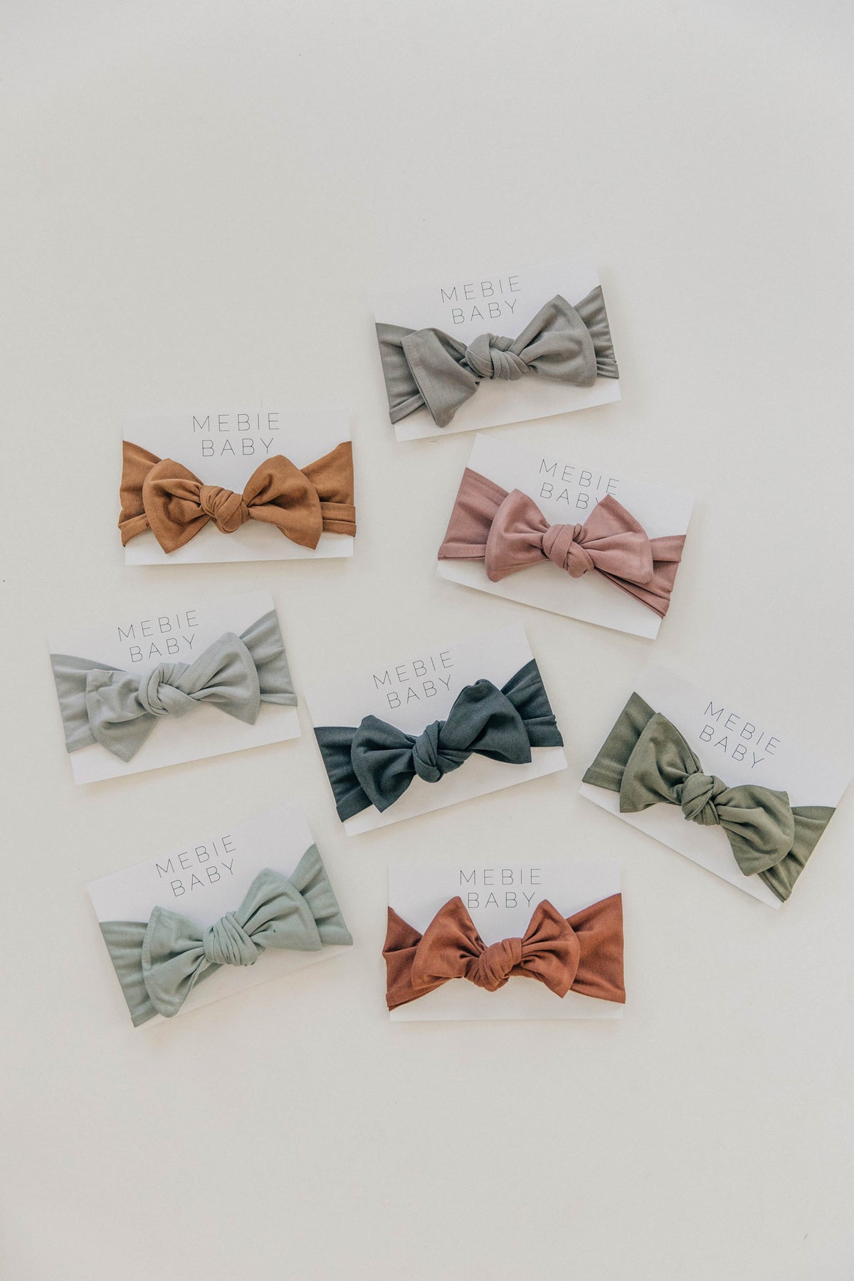Assorted Mebie Baby head wraps in earthy tones displayed on white cards, featuring soft bamboo fabric.