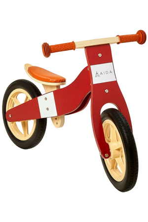 A vibrant red wooden balance bike features a sleek design with a comfortable orange seat, designed for children ages 3 to 5. Its eco-friendly materials ensure safe play and durability.