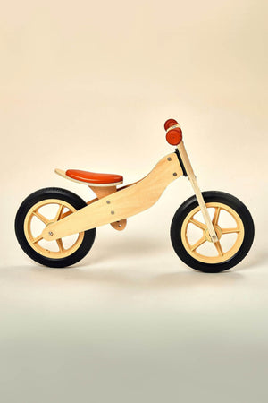A wooden balance bike features a natural finish with orange accents, designed for ages 2 to 4. Its sturdy construction promotes safe play and coordination development for young riders.