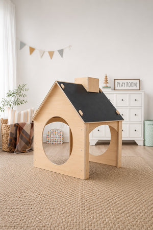 A wooden childrens playhouse features a chalkboard roof and circular openings, set in a bright, airy room with a playful decor.