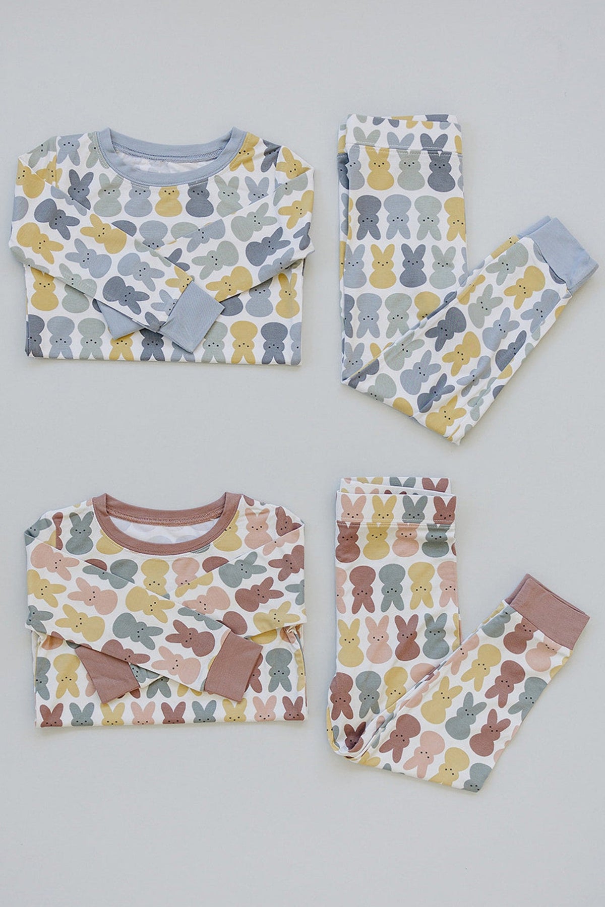 Two sets of childrens pajamas with colorful bunny patterns in pastel shades, featuring long sleeves and pants.