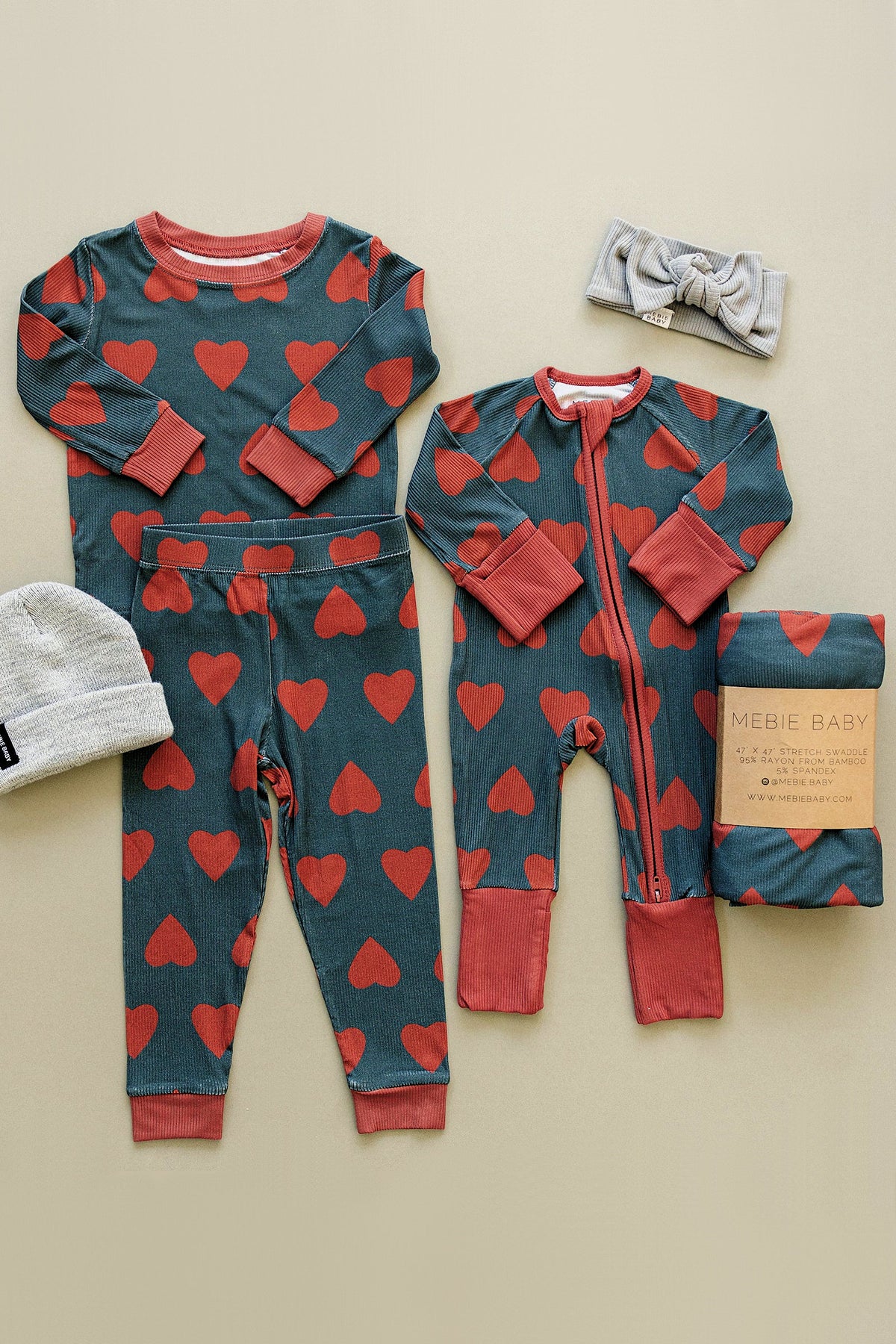 Navy pajama set with red heart patterns, made of bamboo fabric, includes a zipper pajama, pants, and a matching headband.