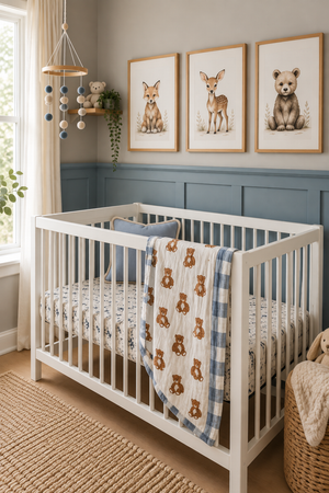 A cozy nursery features a white crib with a teddy bear quilt draped over the side, accompanied by framed animal art on the wall and soft natural light streaming through.