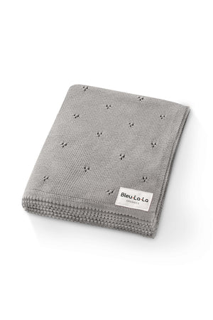 Gray knit blanket with subtle pointelle pattern and a Bleu-La-La Organics label, folded neatly on a white background.
