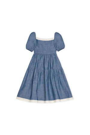 A chambray dress for girls featuring bubble sleeves and delicate crochet trim along the neckline and hem. Ideal for toddlers.