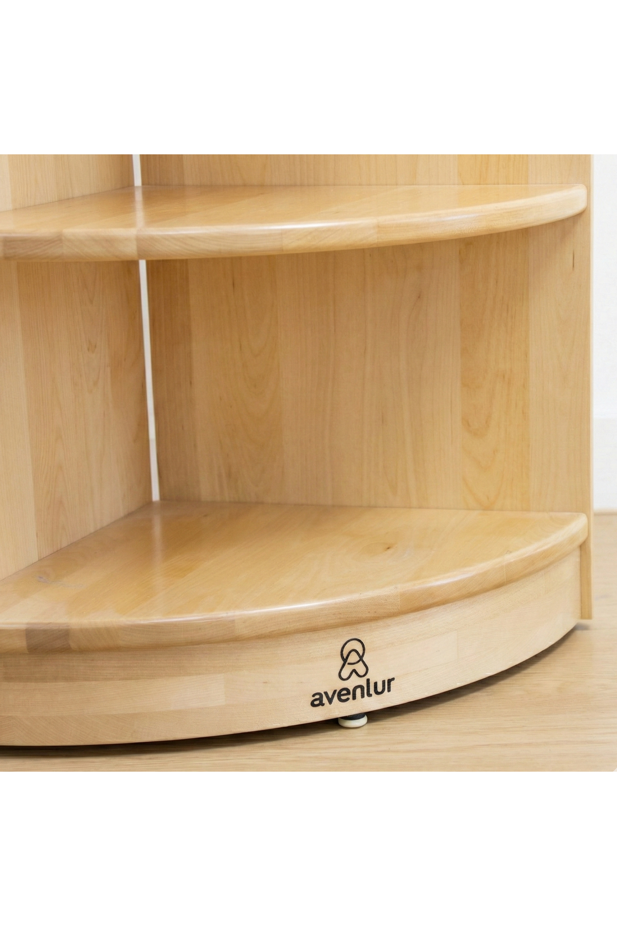 Close-up of a light wood corner bookshelf with smooth, rounded edges, featuring two spacious shelves. The base displays the brand name avenlur, emphasizing its modern, child-friendly design.