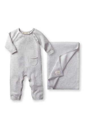 A gray organic cotton romper with a pocket and buttons is displayed alongside a matching jacquard blanket.