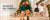 Four children wearing Hope & Henry green sweaters and holiday dresses beside a Christmas tree and garland decorated staircase.