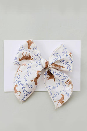 A handcrafted hair bow featuring a playful pony print in soft cotton fabric, accented with delicate blue leaves. Ideal for babies and kids, it adds charm to any outfit.