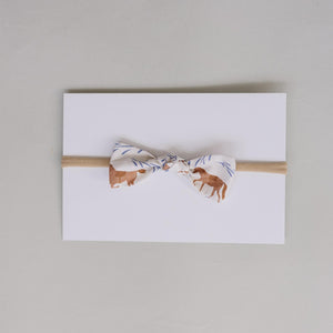 Handcrafted Western pony print hair bow in soft cotton fabric, featuring a neutral tan elastic band. Ideal for babies and kids, adding charm to any outfit.