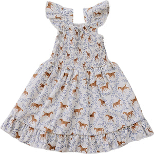 White smocked dress featuring playful pony prints in warm tones, with ruffled sleeves and a flared skirt. Ideal for summer adventures, made from soft, breathable fabric for comfort.