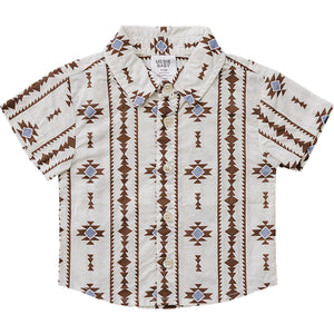 A short-sleeved button-up shirt for babies features a cream background with a brown and blue geometric pattern. Made from lightweight fabric, it combines style and comfort for everyday wear.