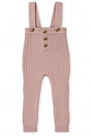 Mauve knit cotton overall for babies and toddlers features a ribbed texture, adjustable straps, and decorative buttons, offering both comfort and style for everyday wear. Made from sustainable cotton.