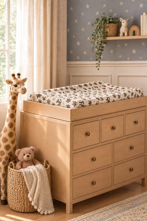 A cozy nursery scene features a wooden changing table topped with a soft muslin changing pad cover adorned with a whimsical rodeo print.