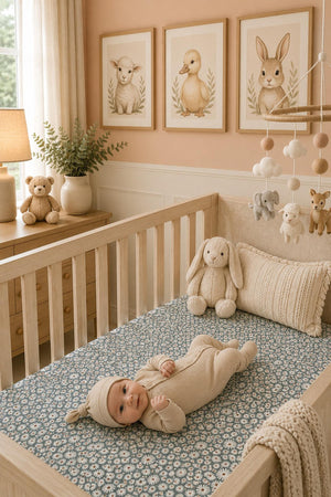 A cozy nursery features a baby lying on a dark green daisy crib sheet, surrounded by soft toys and playful decor, creating a warm and inviting atmosphere for little ones.