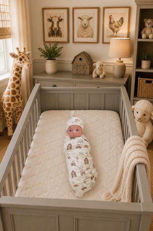 A cozy nursery features a baby swaddled in a Farmhouse Bamboo Stretch Swaddle by Mebie Baby, surrounded by charming animal decor, soft toys, and warm, neutral tones.