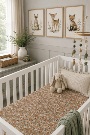 A cozy nursery features a white crib with a floral-patterned muslin crib sheet. The room is decorated with animal prints, a plush bunny, and soft green accents.