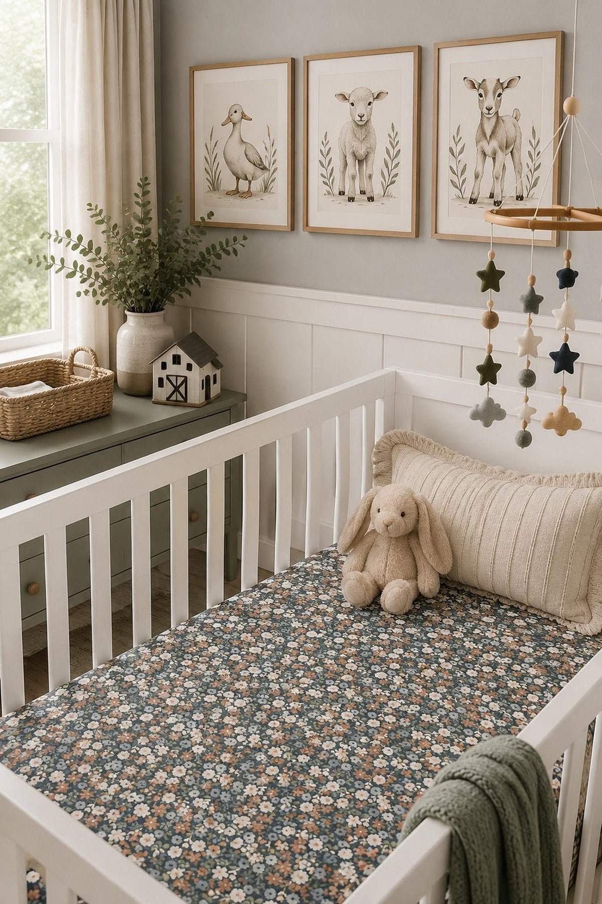 A cozy nursery scene featuring a white crib with a Midnight Floral muslin crib sheet adorned with delicate floral patterns. Soft toys and decorative art enhance the inviting atmosphere.