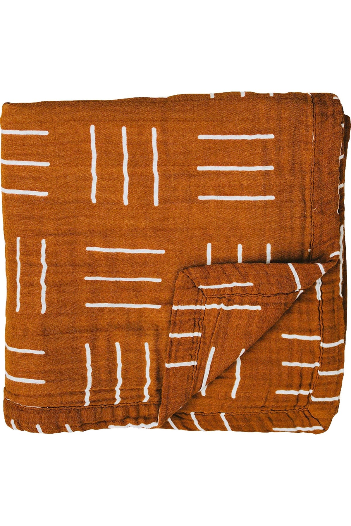 Mustard-colored muslin quilt with white geometric patterns, folded to show layers and texture. Made from 100% cotton.