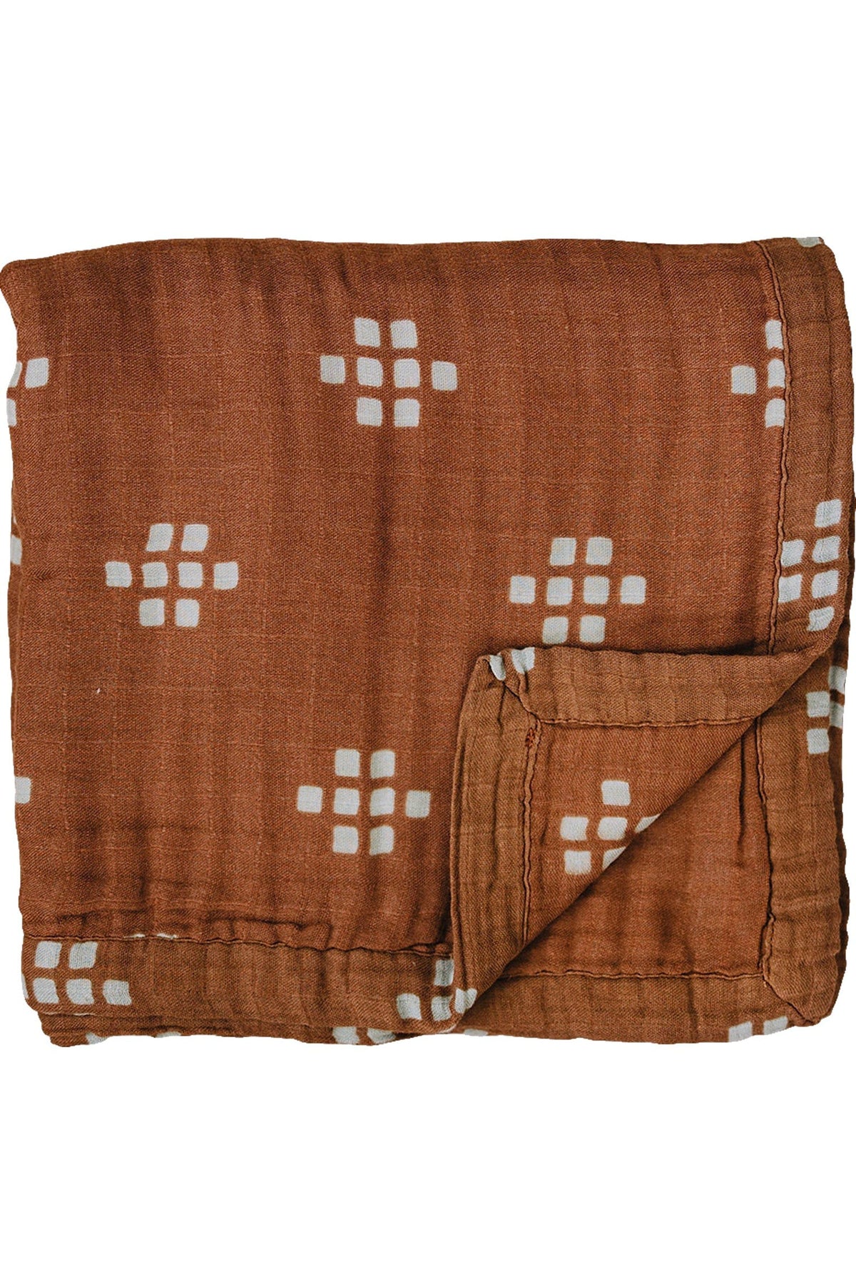 A folded chestnut-colored muslin quilt with white square patterns, made from 100% cotton fabric.