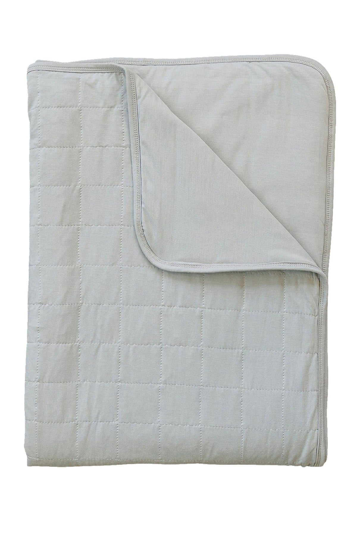 A folded oatmeal-colored quilt with a grid pattern, made from soft bamboo fabric, is laid flat.