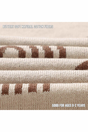 Close-up of a beige knit fabric with brown stripes, emphasizing its soft, natural cotton fibers. Suitable for ages 0-2.
