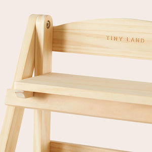 Light-colored wooden storage rack with three shelves, featuring a natural finish and engraved TINY LAND logo, ideal for organizing childrens play food and accessories in a play kitchen setting.