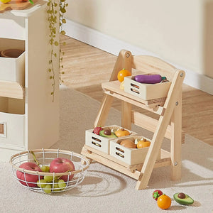 A wooden play food storage rack features two tiers with colorful fruit and vegetable toys in woven baskets. The rack is set against a light-colored wall, enhancing its playful design.