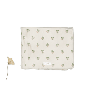 Soft beige cotton blanket featuring a delicate green floral pattern. Perfect for swaddling, this sustainable fabric is ideal for keeping your baby snug and comfortable.