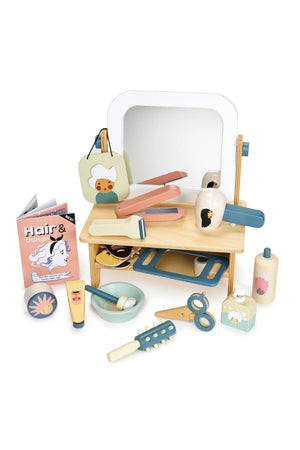 A colorful wooden hair salon set by Tender Leaf Toys features a tabletop mirror, styling tools, and hair care products, made from sustainable materials for imaginative play.