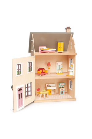 A wooden dollhouse with a light plywood exterior features three rooms, furnished with colorful furniture and accessories.