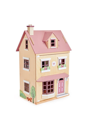 A wooden dollhouse features a pink roof, flower boxes, and a charming door, crafted from sustainable materials for imaginative play.