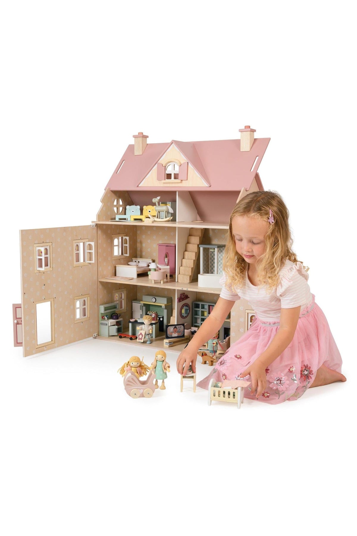 Child playing with a dollhouse and dolls on a white background