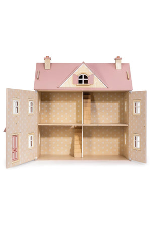 Wooden dollhouse with pink roof and open doors on a white background