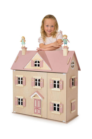 Child with a dollhouse and dolls on a white background