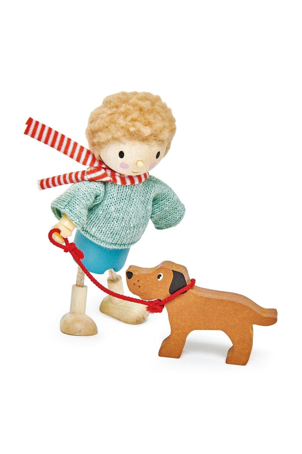 A wooden doll with a curly blonde hairstyle, dressed in a green sweater and blue shorts, walks a wooden dog.