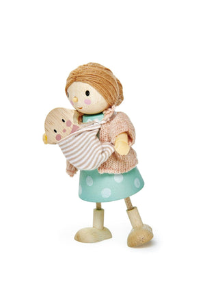A wooden doll with a knitted sweater and polka-dot skirt holds a baby doll in a fabric wrap.