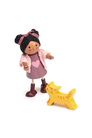 A wooden doll in a pink dress with a heart design, beside an orange wooden cat.